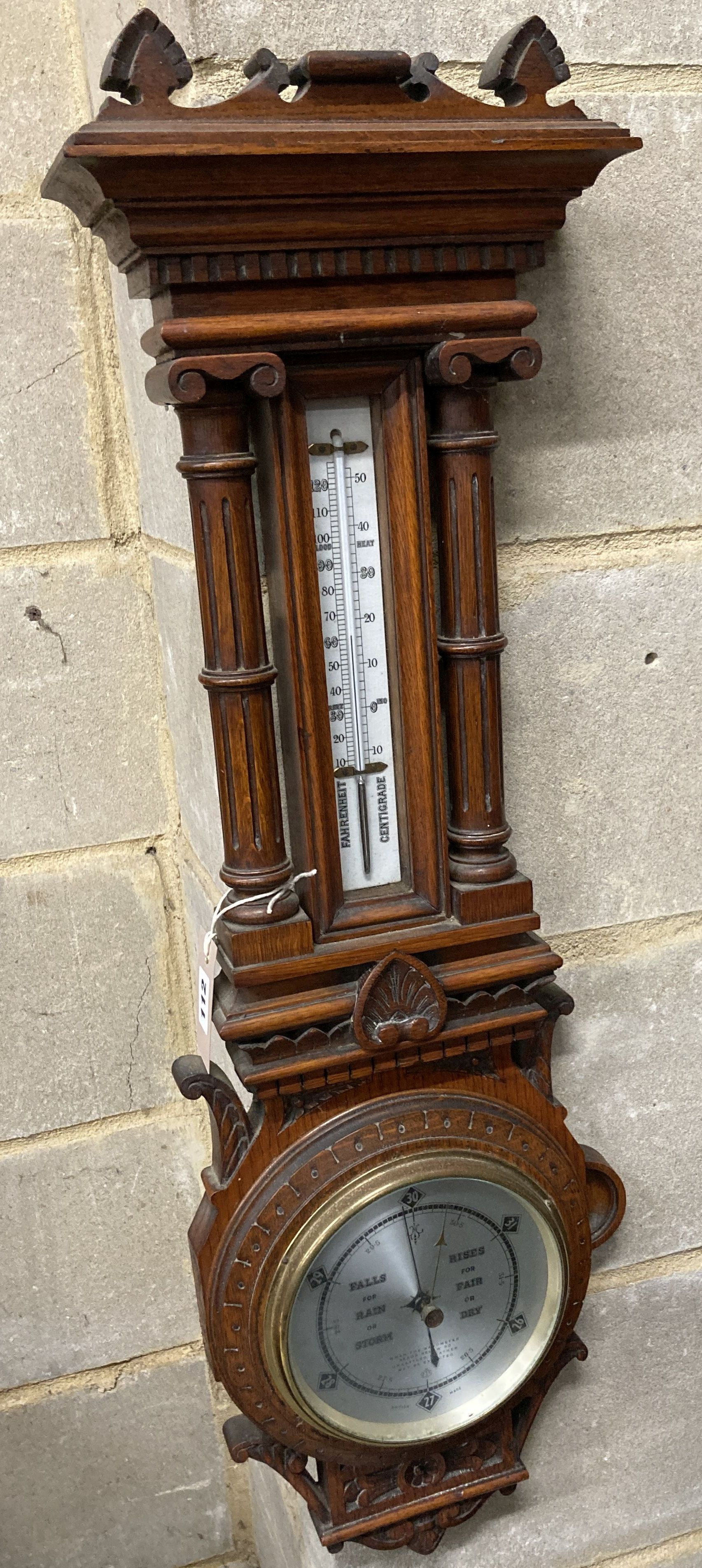 An Edwardian carved oak aneroid barometer and thermometer, height 80cm